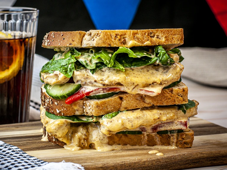 Vegan sandwich served on a wooden board.