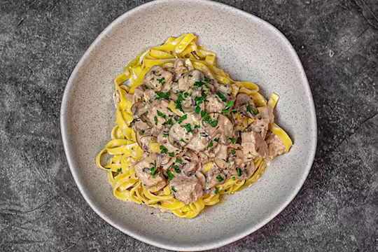Mushroom tagliatelle with Quorn Pieces on top in a dish