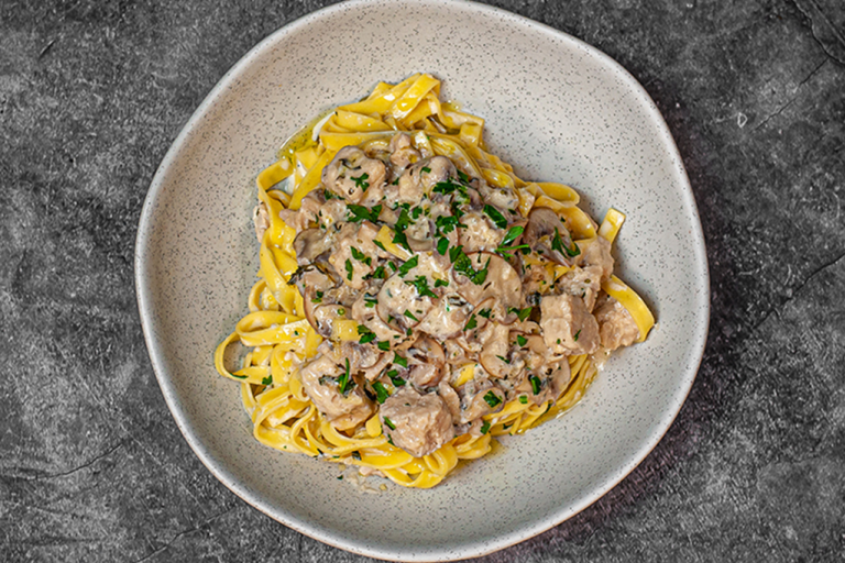 Mushroom tagliatelle with Quorn Pieces on top in a dish