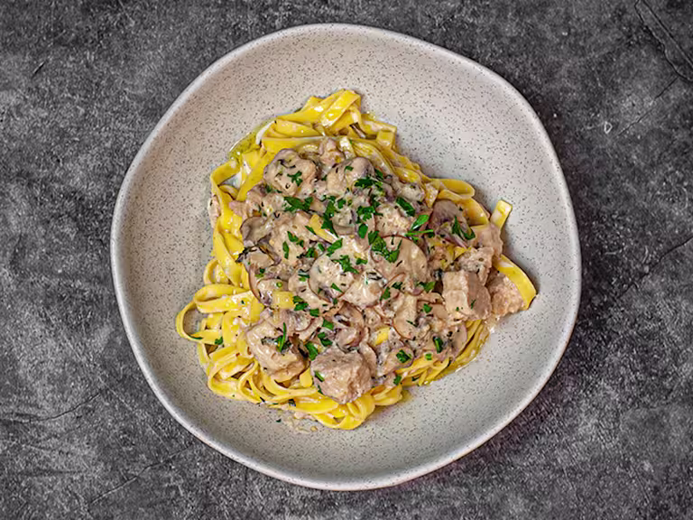 Mushroom tagliatelle with Quorn Pieces on top in a dish