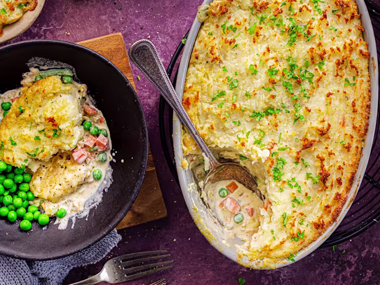 Vegetarian Shepherd's Pie with a slice served in a bowl alongside peas. Quorn Crispy Nuggets packaging displayed.