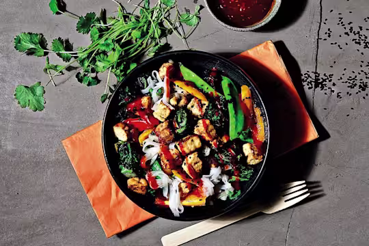 En stor skål med vegetarisk nudelwok med synliga Quorn-bitar, serverad i en mörk skål.