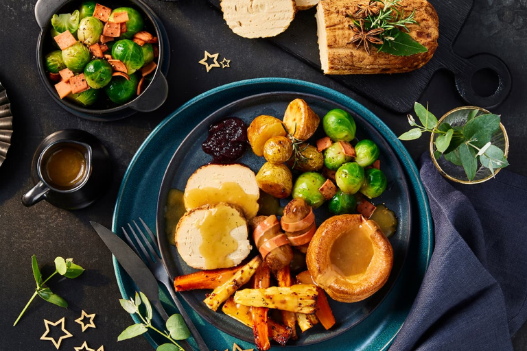 Quorn festive vegetarian spiced roast served alongside trimmings including sprouts, carrots and roast potatoes.