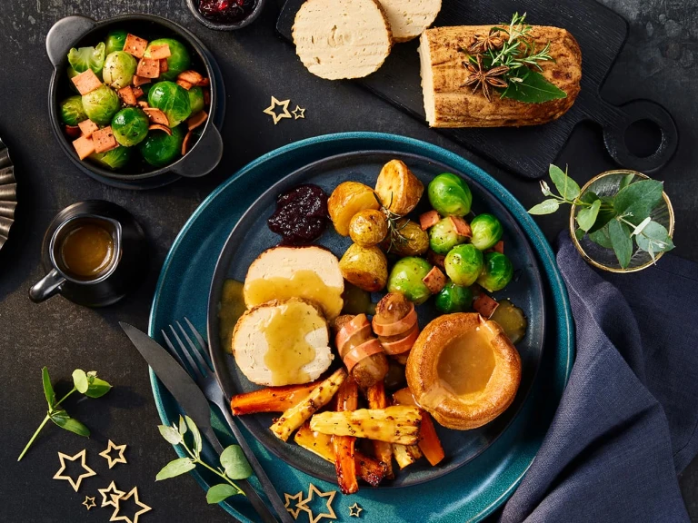 Quorn festive vegetarian spiced roast served alongside trimmings including sprouts, carrots and roast potatoes.