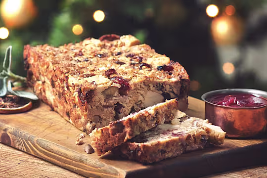 Meatless nut loaf made with Quorn pieces, chestnuts and cranberries next to a pot of sauce