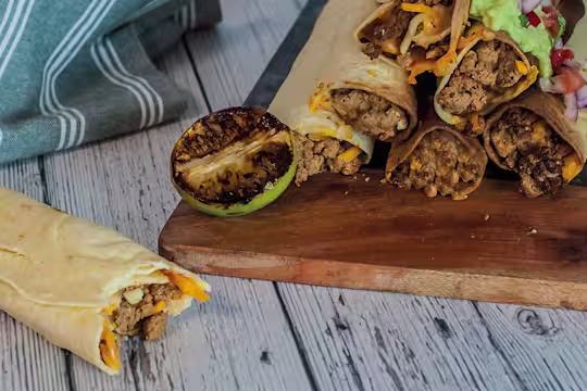 Flour tortillas wrapped and filled with Quorn Mince, sour cream, and cheese, topped with smashed avocado