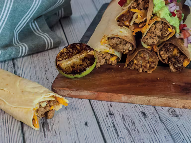 Flour tortillas wrapped and filled with Quorn Mince, sour cream, and cheese, topped with smashed avocado