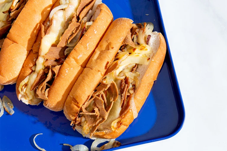 Vegetarian Philly Cheesesteak Sandwich with Quorn Roast Beef Style Slices on a blue tray