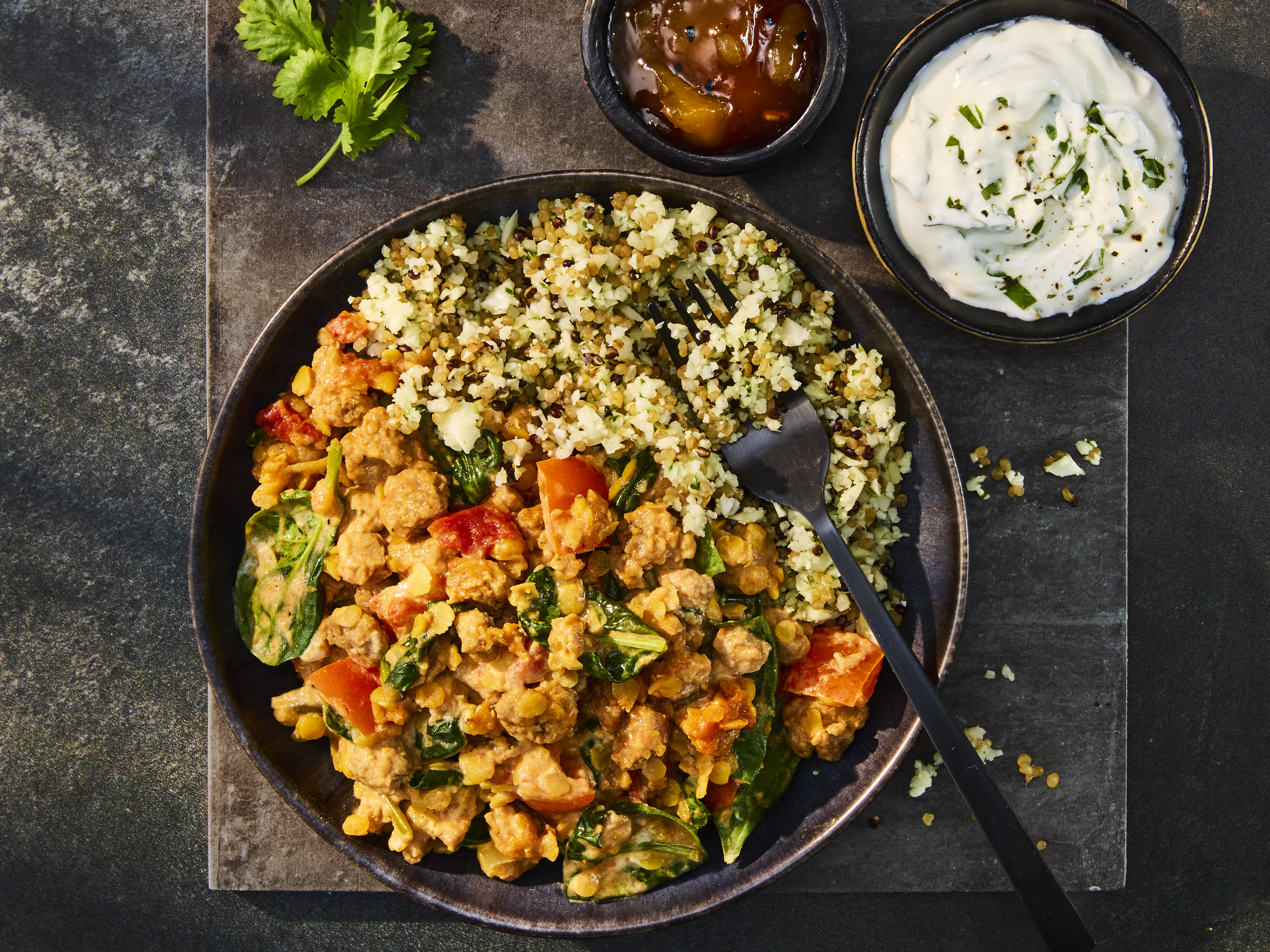 A tasty bowl of Quorn Mince Keema Dal served with Cauliflower Rice, chutney, and a yogurt dip.