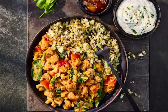 A tasty bowl of Quorn Mince Keema Dal served with Cauliflower Rice, chutney, and a yogurt dip.