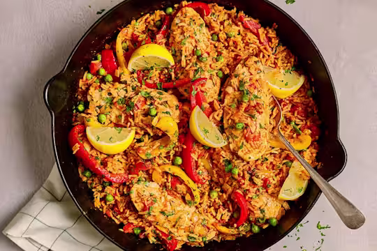 A full pan of Quorn Vegetarian Spanish Chicken and Rice with Quorn Fillets shown and garnished with peppers and lemon slices.