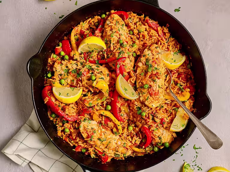 A full pan of Quorn Vegetarian Spanish Chicken and Rice with Quorn Fillets shown and garnished with peppers and lemon slices.