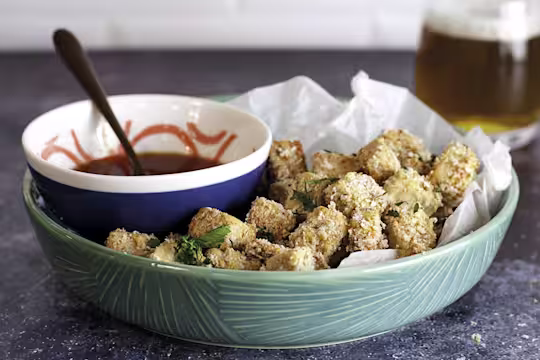 A bowl of popcorn Quorn Vegan Pieces with a bowl of buffalo sauce on the side.
