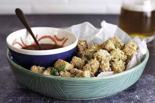 A bowl of popcorn Quorn Vegan Pieces with a bowl of buffalo sauce on the side.