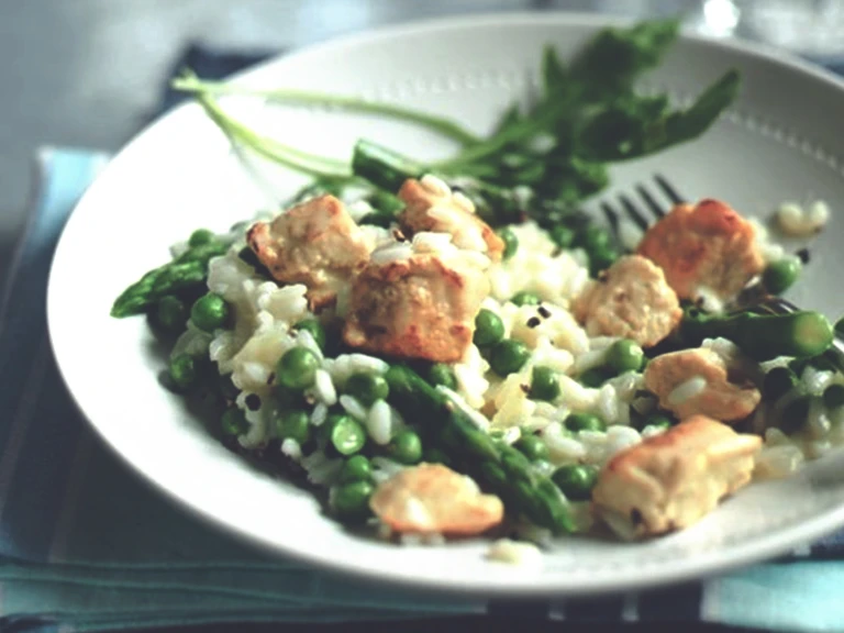 Vegetarian risotto with peas, asparagus and Quorn Meatless Chicken visible served on a while dish.