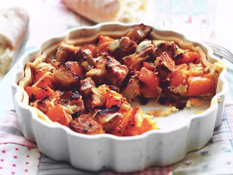 Quick and easy meal of butternut squash tart made with Quorn Pieces served in a fluted ceramic dish with a portion cut out
