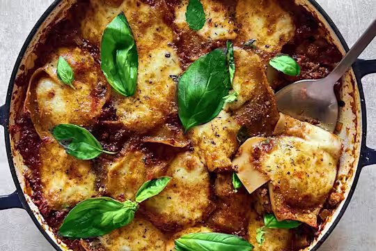 A large pot of vegetarian lasagne made using Quorn Mince topped with basil leaves.