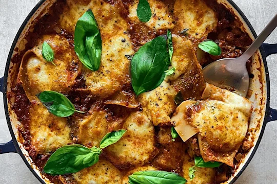 A large pot of vegetarian lasagne made using Quorn Mince topped with basil leaves.
