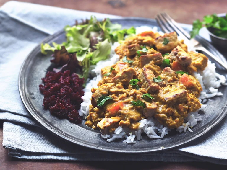 A plate of vegetarian katsu curry with Quorn Pieces, rice and a side salad.