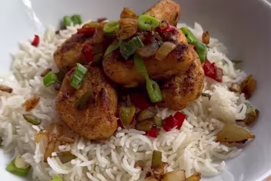 Quorn Crispy Nugget sat on top of a red of rice topped with garnish.