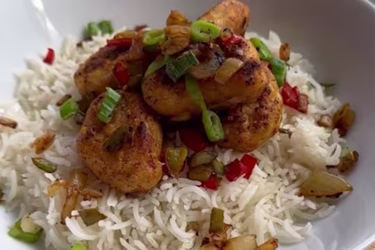 Quorn Crispy Nugget sat on top of a red of rice topped with garnish.