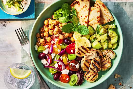 A large Gyros bowl with veggies and chickpeas and a side of homemade tzatziki