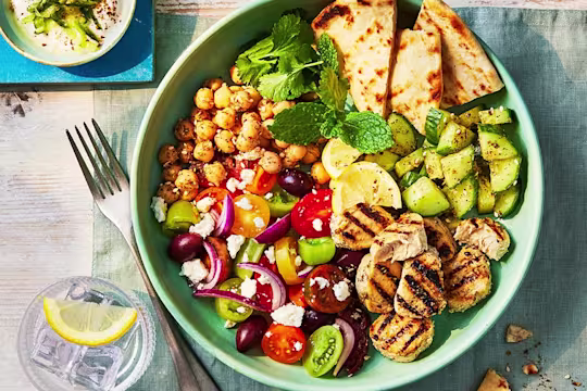 A large Gyros bowl with veggies and chickpeas and a side of homemade tzatziki
