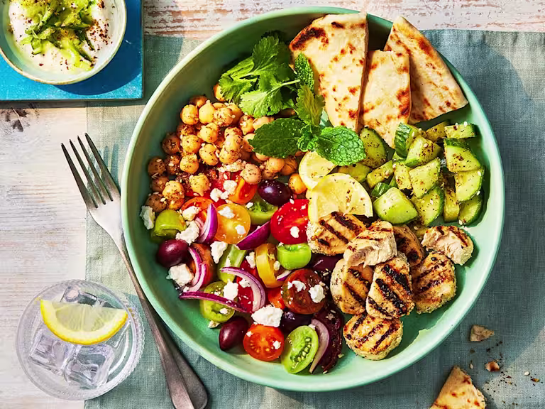 A large Gyros bowl with veggies and chickpeas and a side of homemade tzatziki