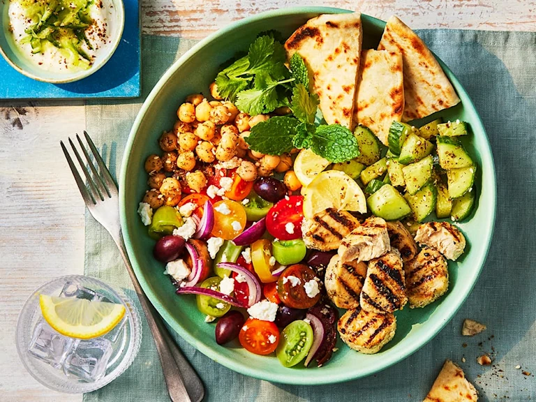 A large Gyros bowl with veggies and chickpeas and a side of homemade tzatziki