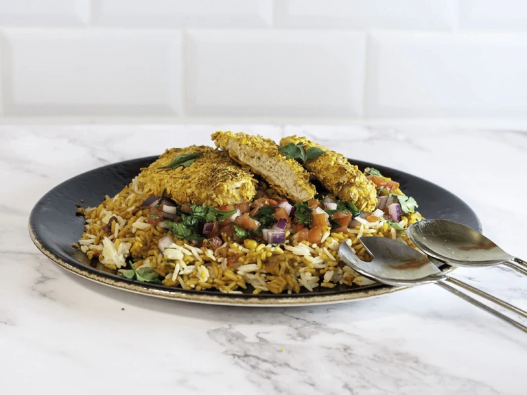 Dorito-crumbed Quorn Fillets atop a bed of rice with a tomato, red onion, and coriander salsa.