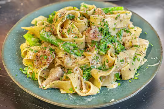 Creamy sausage and broccoli pasta served on a green plate