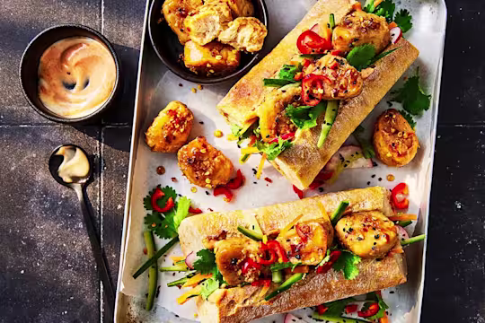 Two Quorn vegetarian Banh Mi served on a tray with sauce on the side