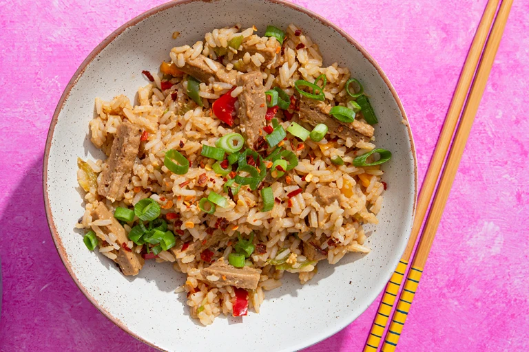Teriyaki style Quorn Vegetarian Steak Strips with egg fried rice in a bowl with chopsticks