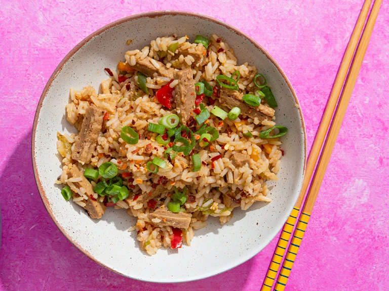 Teriyaki style Quorn Vegetarian Steak Strips with egg fried rice in a bowl with chopsticks