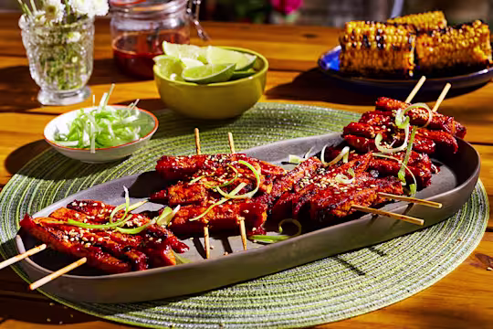A platter with four servings of Korean BBQ Skewers made with Quorn Fillets topped with sesame and scallions.