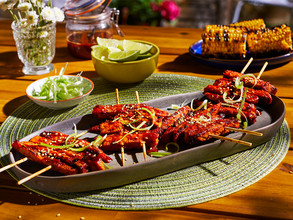 A platter with four servings of Korean BBQ Skewers made with Quorn Vegan Fillets topped with sesame and scallions.