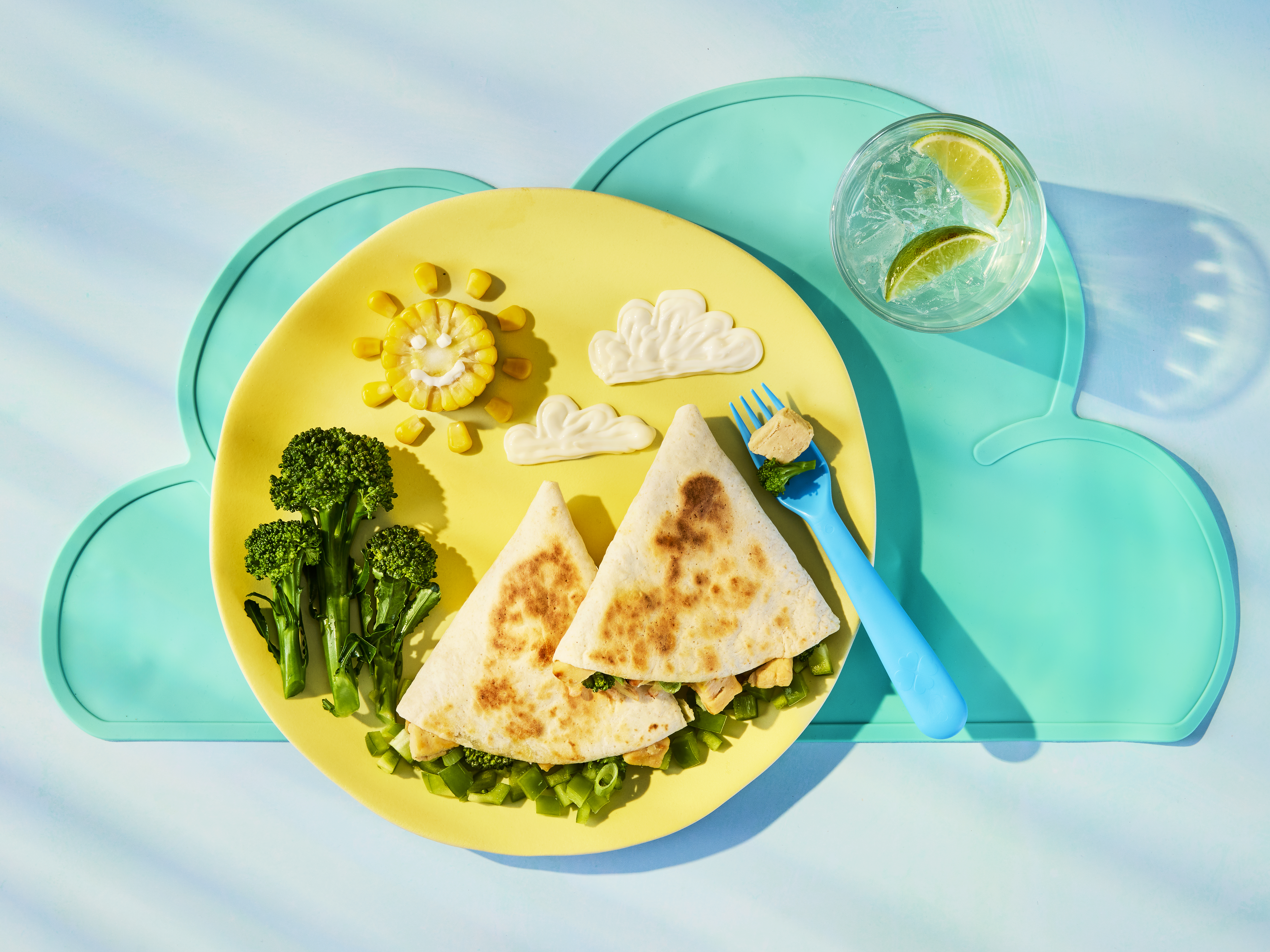 Tortilla wraps filled with Quorn Pieces, broccoli, sweetcorn and melted cheddar. Served with broccoli and sweetcorn on a plate.