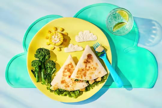 Tortilla wraps filled with Quorn Pieces, broccoli, sweetcorn and melted cheddar. Served with broccoli and sweetcorn on a plate.