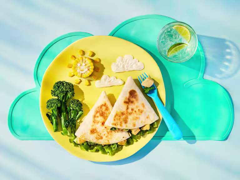 Tortilla wraps filled with Quorn Pieces, broccoli, sweetcorn and melted cheddar. Served with broccoli and sweetcorn on a plate.