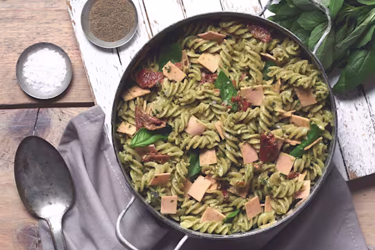 Vegan pasta made with Quorn Gluten Free Vegan Smoky Ham, sundried tomato, basil and fusilli pasta in pesto served in a bowl