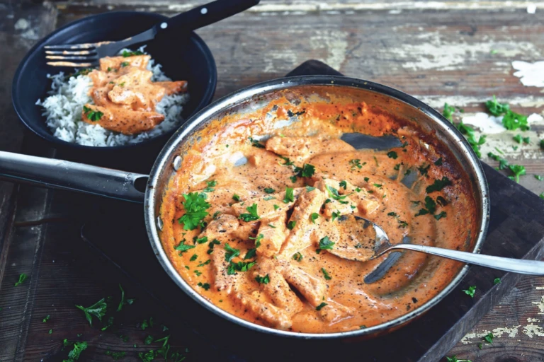 A serving of vegetarian stroganoff made with Quorn Vegetarian Steak Strips and mushrooms in a white dish with the baking dish in the background.