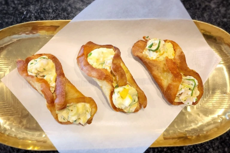 Three fried egg rolls with Quorn Pieces on a gold tray. 