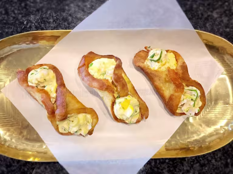 Three fried egg rolls with Quorn Pieces on a gold tray.