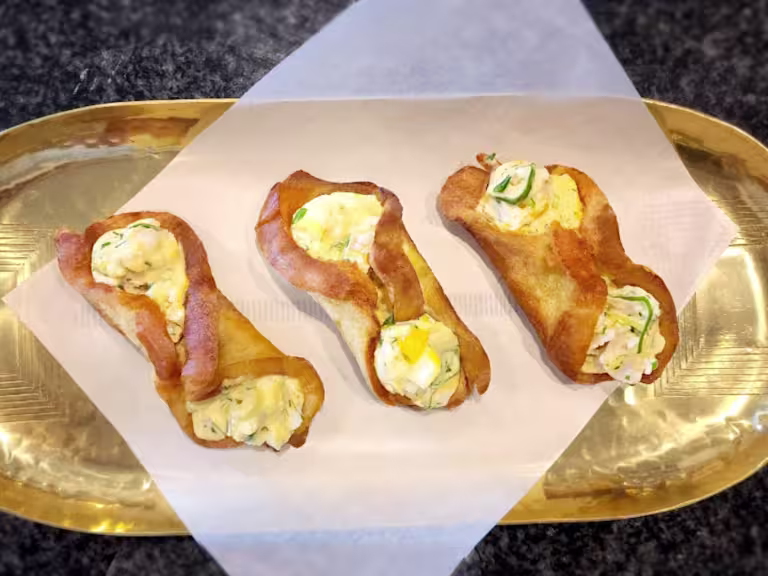 Three fried egg rolls with Quorn Pieces on a gold tray.