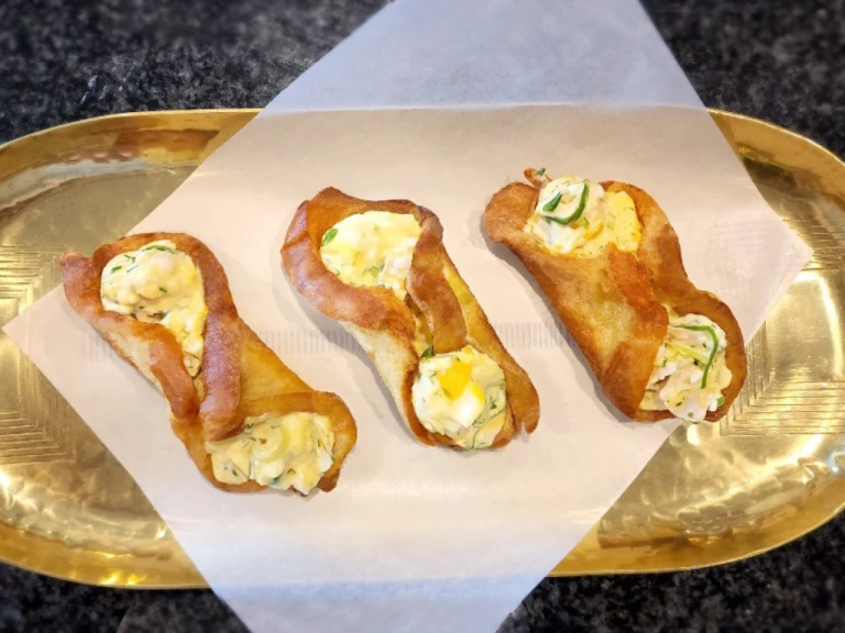 Three fried egg rolls with Quorn Pieces on a gold tray. 