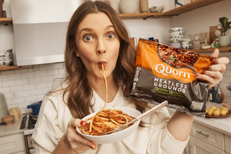 Drew Barrymore holding a bag of Quorn Meatless Grounds