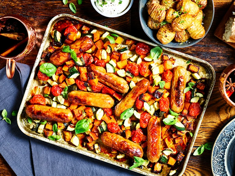 A traybake with Quorn Sausages, butternut squash, tomatoes, and courgette.