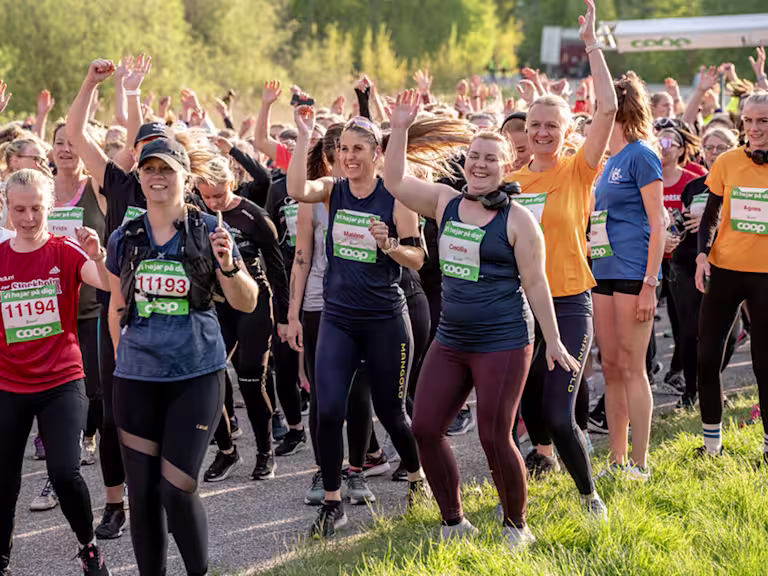 En skara människor springer medan de skrattar och hejar.