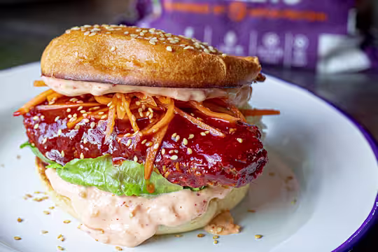 Vegetarian Sweet and Spicy Ramen Burger showing the fillings including grated carrots, lettuce and mayonnaise.