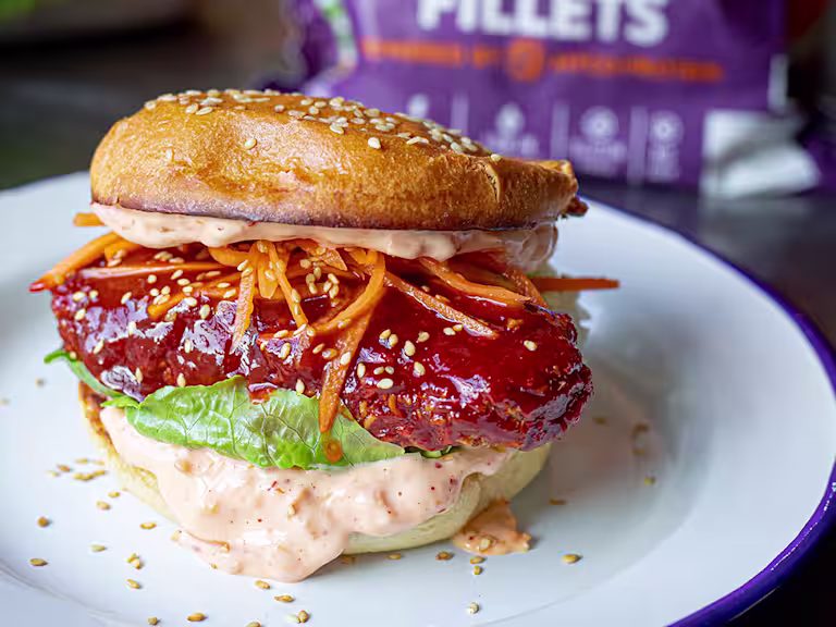 Vegetarian Sweet and Spicy Ramen Burger showing the fillings including grated carrots, lettuce and mayonnaise.